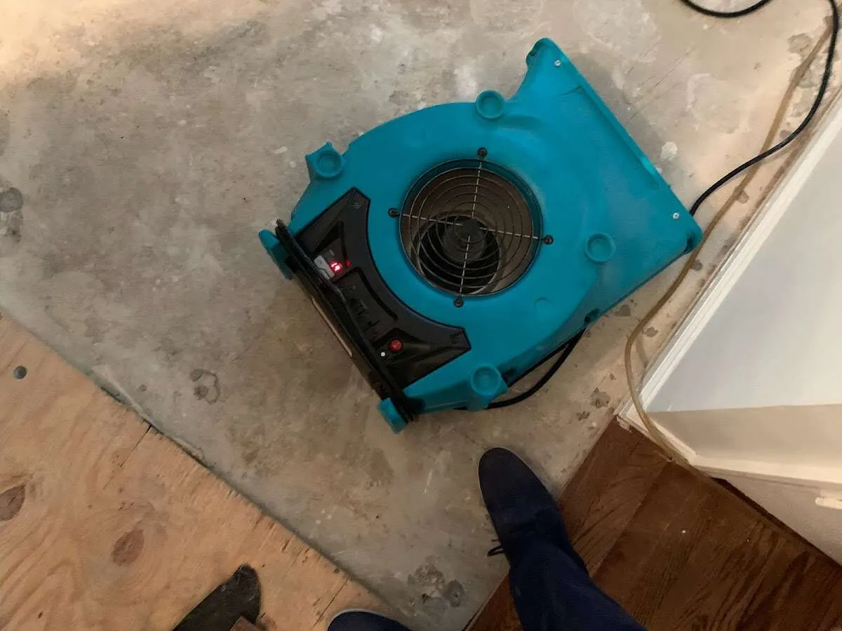 Air mover drying subfloor during Leak Detection & Repair in Eaton